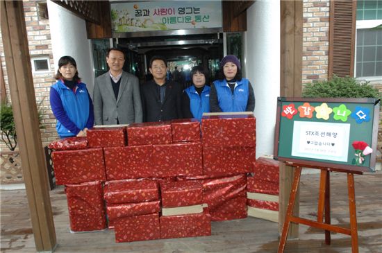 STX 경남지역 가족봉사단원들이 18일 지역 복지시설을 방문해 생활용품을 전달한 뒤 기념촬영하고 있다.