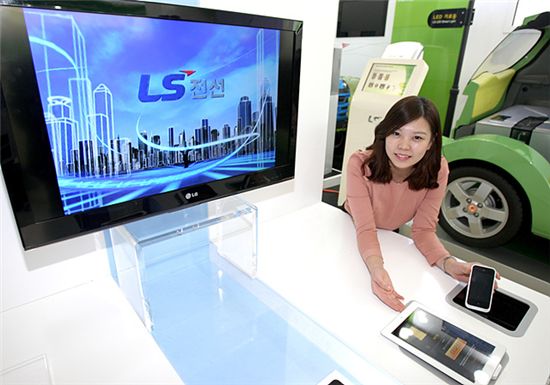 LS전선은 26일 최대 2m 거리까지 선없이 전력을 전송할 수 있는 자기공명 무선전력 전송 시스템을 선보였다. LS전선 직원이 자기공명 무선 전력 전송 시스템으로 작동 중인 TV와 스마트폰등을 선보이고 있다. 