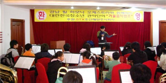 경남필하모닉오케스트라 강만호 지휘자(맨 뒷줄 가운데)와 단원들이 중국 다롄시 개발구 잉화호텔에서 열린 대련 청소년 관악단 겨울음악캠프에 참가해 음악교육을 실시하고 있다.