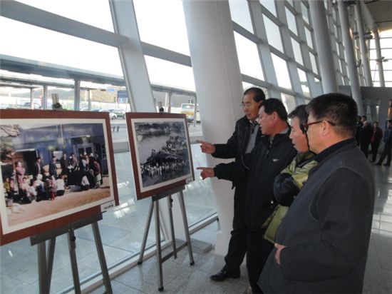 KTX 울산역을 찾은 기차손님들이 '울산공업센터지정 50주년 사진기록물'들을 보고 있다.