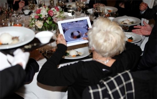 ▲ 환영만찬에 초대된 한 참석자가 음식을 맛보기 전 자신의 태블릿PC로 사진을 찍고 있다.