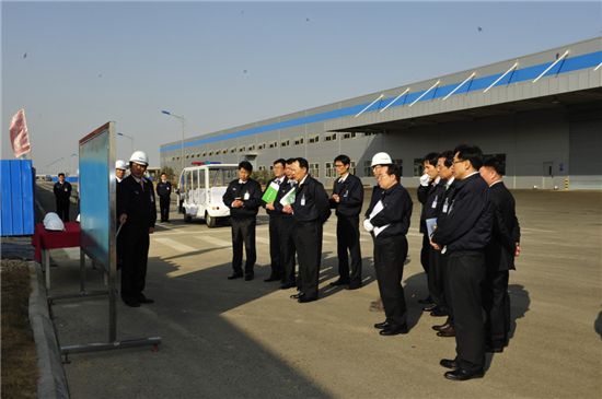 배인규 현대위아 사장(자동차 기준 왼쪽으로 네번째)이 중국 산동법인에 건설중인 제3공장 현장을 방문해 임직원들로부터 현황보고를 받고 있다.