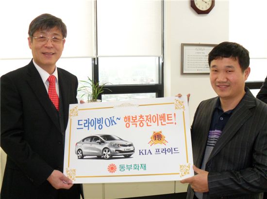 박윤식 동부화재 부사장(왼쪽)과 1등 경품으로 소형자동차를 받은 임숙호씨가 기념촬영을 하고 있다. 
