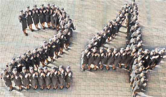 서울 강서구 오쇠동 아시아나타운에서 아시아나항공의 창립 24주년을 기념해 창립연도인 1988년에 태어난 용띠 신입 승무원들이 '24' 대형을 만들어 기념촬영을 하고 있다. 
 
