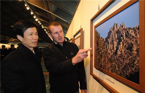 뉴질랜드 산악인 로저 세퍼드(오른쪽)씨가 자신이 찍은 남북한 백두대간 사진작품을 이돈구 산림청장에게 설명하고 있다.