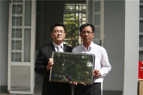 아주복지재단이 이달 베트남 빈탄초등학교에 '아주행복도서관'을 완공했다. 천정준 아주베트남 법인장(사진 왼쪽)이 응우웬 방 딘 빈탄초등학교장과 함께 기념촬영을 하고 있다.