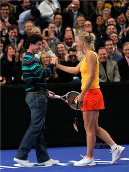  로리 매킬로이(왼쪽)가 애인 캐롤라인 워즈니아키의 손에 이끌려 마리아 샤라포바와의 테니스 대결을 준비하고 있다. 