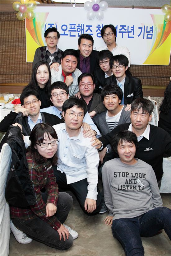 삼성SDS의 자회사형 장애인 표준사업장 오픈핸즈 김인수 대표(맨 뒷줄 가운데)가 창립 1주년 기념행사장에서 직원들과 기념 촬영을 하는 모습. 