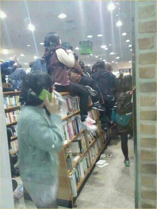 블락비의 팬들이 서점 책장에 올라가 멤버들을 구경하고 있다.(출처 : 트위터)