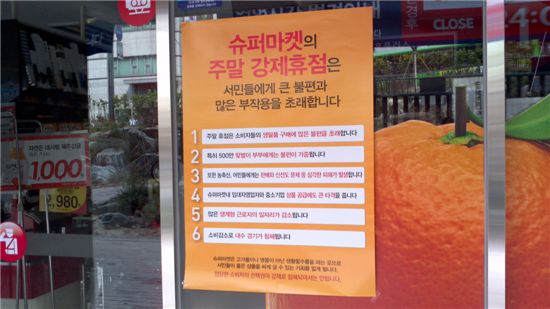 서울 성북구 홈플러스 익스프레스 매장입구에 8일 슈퍼마켓 주말 강제휴무에 따른 불편함을 지적한 포스터가 매장 입구에 붙어있다.