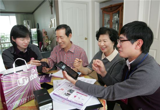 사진은 한 고객이 집에서 LG유플러스 직원들에게 스마트폰과 태블릿PC 이용방법을 안내받고 있는 모습.