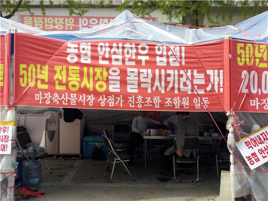 마장동 축산물 시장 상인들은 생업을 중단하고 농협 안심한우 육가공업체 입점 결사반대 플랜카드를 걸어놓고 농성 중이다.