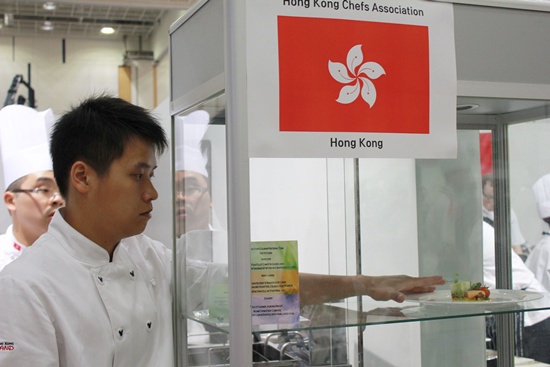 홍콩에서 온 한 조리사가 심사위원들의 심사를 받기 전에 요리의 위치를 조정하고 있다.