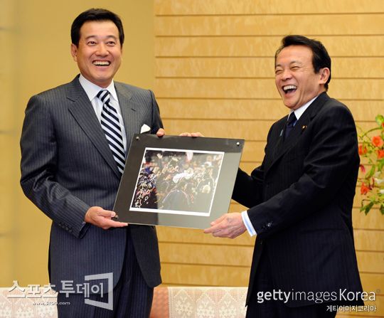 일본대표팀을 2009 월드베이스볼클래식 우승으로 이끈 하라 다츠노리 감독(왼쪽)이 아소 다로 전 일본 총리로부터 기념사진을 넘겨받은 뒤 활짝 웃고 있다.[사진=Getty images/멀티비츠]