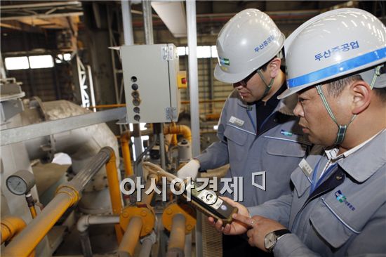 경남 창원 두산중공업 단조공장에서 온실가스 담당자들이 탄소배출 계측기 수치를 확인하고 관련 설비를 점검하고 있다