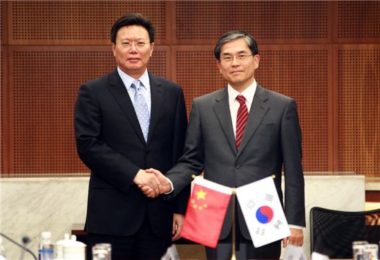 최석영 FTA교섭대표(오른쪽)와 위지앤화 중국 상무부 부장조리가 14일 한중FTA 1차협상 후 악수하고 있다.