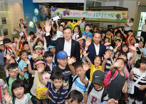 NH농협은행의 신충식 행장(왼쪽)과 김용복 부행장이 '꿈나무 어린이 초청 후토스 이벤트'에 초청된 농촌지역 어린이들과 기념촬영을 하고 있다.