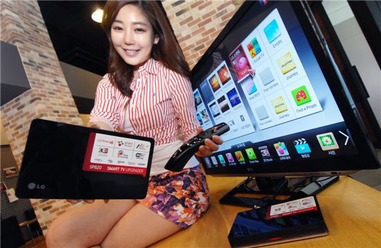 LG전자 모델이 서울 여의도 LG 트윈타워에서 일반 TV로도 스마트 기능을 사용할 수 있게 하는 스마트TV 업그레이더를 소개하고 있다.
