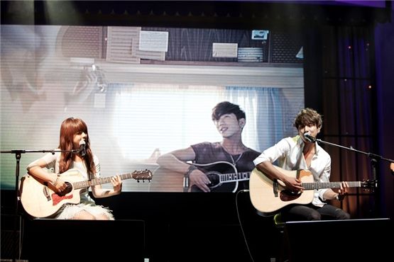 Songstress Juniel (left) and CNBLUE's leader Jung Yong-hwa (right) performing at Juniel's debut showcase held in Seoul, South Korea on June 7, 2012. [FNC Entertainment]