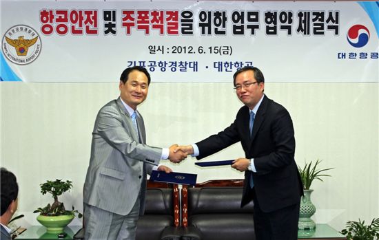 대한항공 이종석 여객운송총괄 본부장(사진 오른쪽)과 홍원표 김포공항 경찰대장이 항공안전 및 주폭척결을 위한 업무협약 체결식에서 상호간 협약서를 교환하고 있다.

