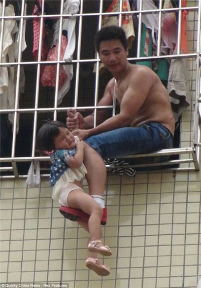 ▲ 중국 광저우의 한 아파트에서 부부싸움을 벌이던 남성이 6층 창문에 자신의 딸을 매단 채 앉아 있다. (출처: 데일리메일)