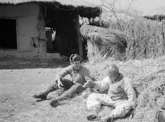 호주 병사가 지역 농부에게 담배를 권하는 모습(1951).