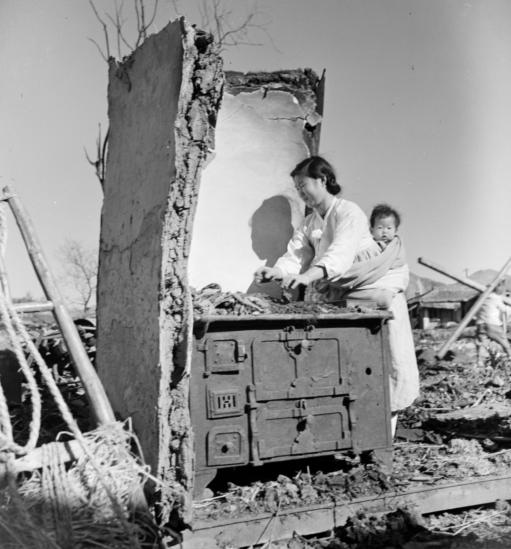 파괴된 부엌을 살피는 여인(1950).