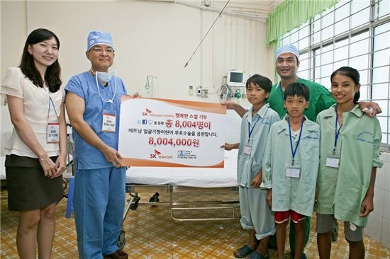 백롱민 분당서울대병원 박사(왼쪽 두번째)와 SK텔레콤 관계자가 얼굴기형 무료 수술을 받은 베트남 어린이들에게 ‘행복한 소셜 기부’ 캠페인을 통해 모금된 기부금을 전달하고 있는 모습.  