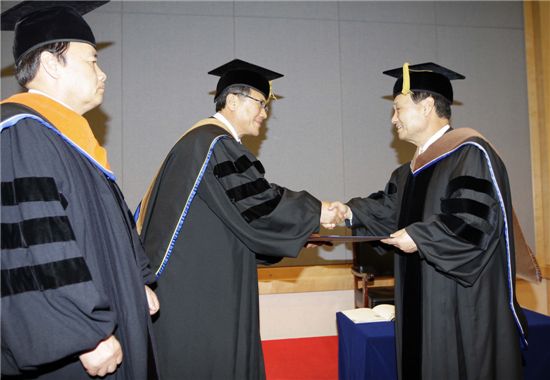 정상철 충남대학교 총장(왼쪽에서 두 번째)이 이팔성 우리금융 회장(오른쪽)에게 학위를 수여하고 있다.