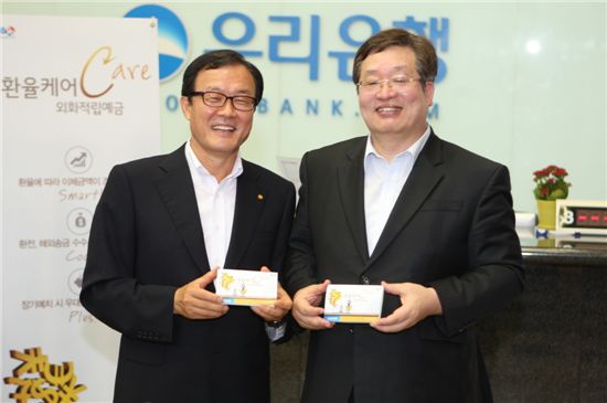 ▲3일 회현동 우리은행 본점영업부에서 이순우 우리은행장(좌)과 주재성 금융감독원 부원장(우)이 '환율CARE 외화적립예금'에 가입한 후 기념촬영을 하고 있다.