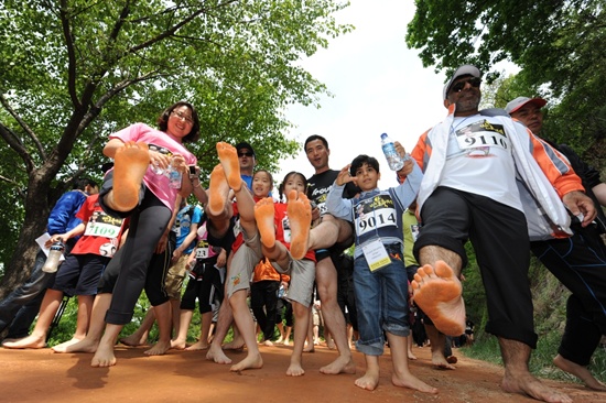 대전충남지역 소주업체 선양이 주최한 계족산 맨발걷기 대회에 참가한 시민들이 발을 들어보이고 있다.