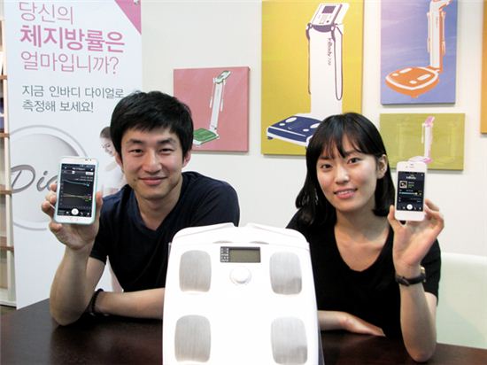 바이오스페이스 직원들이 체지방측정기 '인바디다이얼'과 스마트폰 앱 '헬로인바디'를 소개하고 있다.
