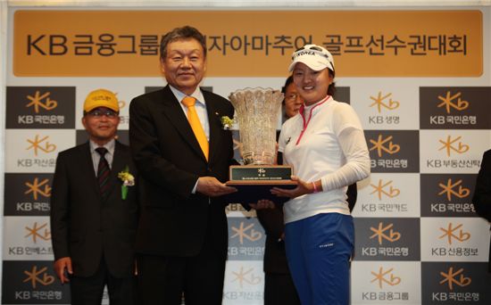 12일 어윤대 KB금융그룹 회장(왼쪽)이 고진영 선수(오른쪽)에게 KB금융그룹배 여자아마추어 골프선수권대회 우승컵을 전달하고 있다.