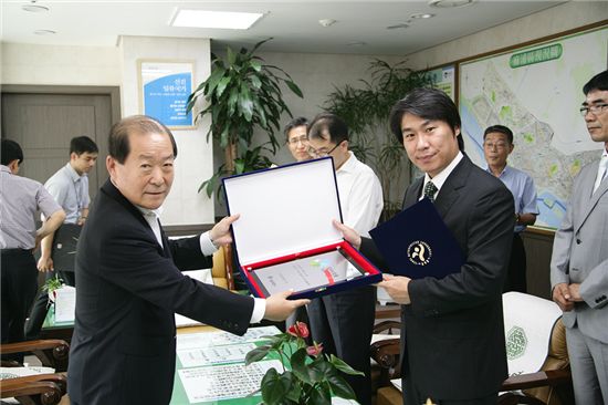 박홍섭 마포구청장(왼쪽)이 2012 상반기 일자리창출 우수기업으로 선정된 업체 관계자들에게 인증서를 전달했다.