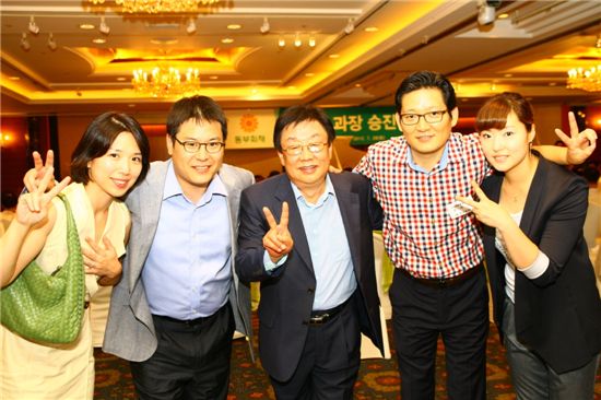 승진자 축하연에 참석한 신임과장과 가족들이 동부화재 김정남 사장(가운데)과 기념 촬영을 하고 있다.

