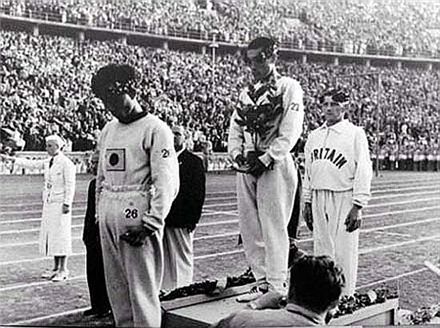 ▲ 손기정 선수가 1936년 베를린올림픽 마라톤 시상식에서 자신의 유니폼에 그려져 있는 일장기를 월계수로 가리고 서 있다. (출처: 위키피디아) 