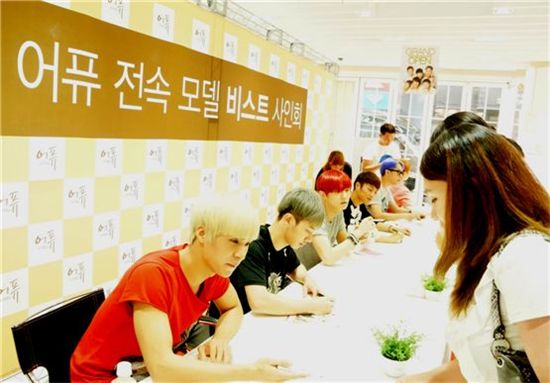 BEAST members Son Dong-woon (left), Lee Gi-kwang (second to left), Jang Hyun-seung (third to left), Yoon Du-jun (third to right), Yong Jun-hyung (second to right) and Yang Yo-seop (right) signing their autographs for fans at the group's autograph session for Korean cosmetics brand A’PIEU held in Seoul's Myeongdong shopping district on July 31 [PR Bridge]