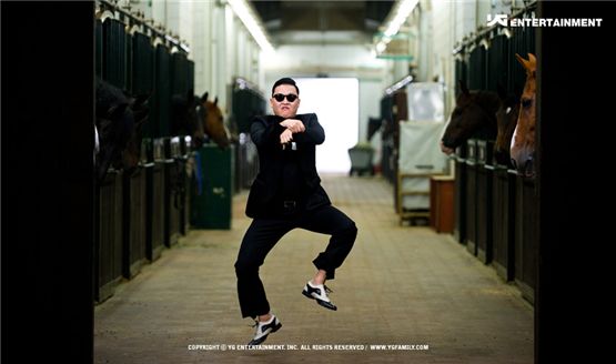 PSY dancing his signature horse-riding choreography donned in a black suit in the music video for "Gangnam Style" listed in his sixth studio album "Six Rules, Part. 1," dropped on July 15, 2012. [YG Entertainment] 