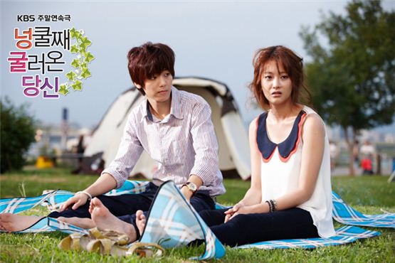 K-pop boy band CNBLUE's Kang Min-hyuk (left) and actress Oh Yeon-seo (right) sit on the grass in a park in KBS' "My Husand Got a Family" aired on August 5, 2012. [KBS]