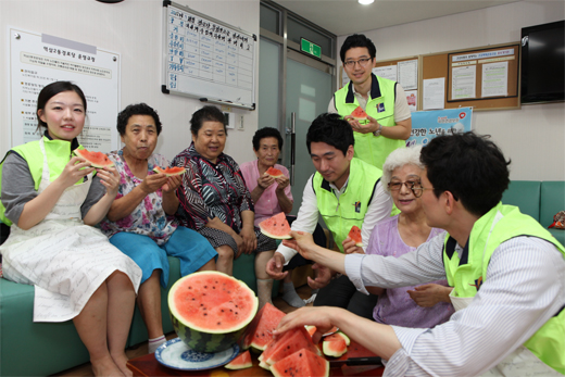 ▲SPC그룹 임직원들이 서울 역삼노인종합복지관을 방문해 어르신들과 함께 수박을 먹으며 이야기를 나누고 있다.
