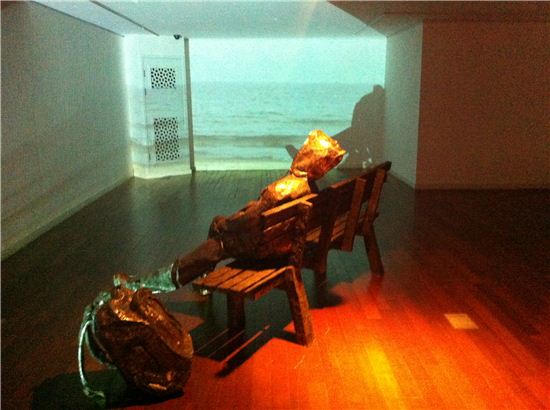 투명인간-배낭하나 들고 와 홀로 벤치에 앉아있는, 해운대를 배경으로 한 스크린, 2012 