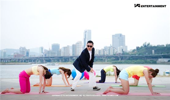 A still shot of PSY dancing with people doing yoga in the background for his music video "Gangnam Style" listed in his sixth studio album "Six Rules, Part. 1," dropped on July 15, 2012. [YG Entertainment] 
