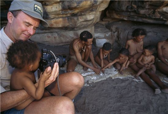 내셔널 지오그래픽의 편집장 크리스 존스(Chris Johns)가 아프리카 남부 칼라하리 사막에서 살고 있는 부시먼 족들과 여유시간을 즐기고 있는 모습.