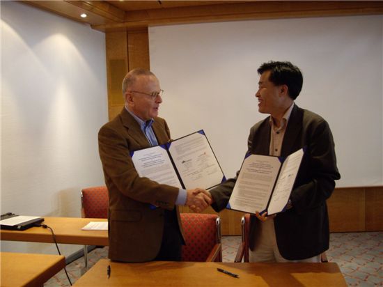 전범권(오른쪽) 치유사업단장과 폰 하우젠 오버탈 대표가 양해각서(MOU)를 주고받으며 악수하고 있다.