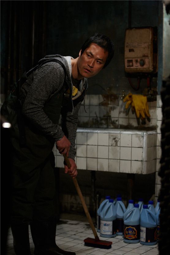 Kim Sung-kyun as the murderer Ryu Seung-hyuk cleans up the blood after killing a person in his basement for a scene in suspense thriller "My Neighbor" set to hit local theaters on August 23, 2012. [Lotte Entertainment]