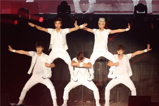 2PM members Junsu (top left), Wooyoung (top right), Chansung (bottom left), Taecyeon (bottom middle) and Junho (bottom right) donned in white shirts and pants showcase a human pyramid during their performance at their firm's joint concert “JYP NATION in Japan 2012,” held at the Yoyogi National Stadium in Tokyo, Japan on August 18 and 19. [JYPE]
