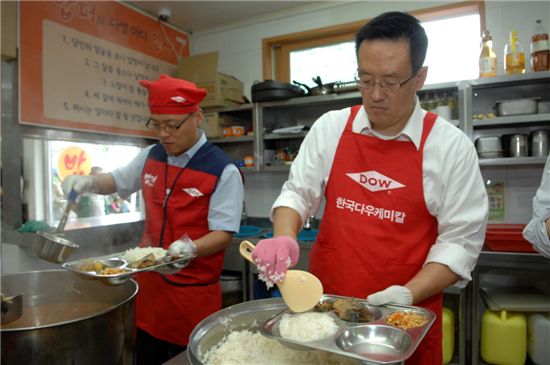 한국다우케미칼 양창원 사장(오른쪽)과 임직원들이 밥퍼나눔운동본부 내 무료급식소에서 점심 배식을 하고 있는 모습. 
