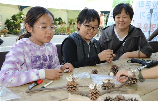‘2011대한민국산림박람회’ 때 나무 목공예품을 만들어보고 있는 어린이들.