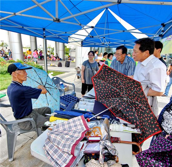차성수 금천구청장이 벼룩시장을 방문해 우산 고쳐주는 어르신과 얘기를 나누고 있다.