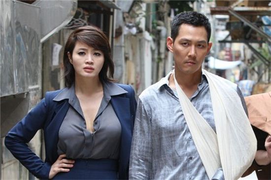 Kim Hye-soo (left) and Lee Jung-jae (right) pose together during the shooting of "The Thieves," opened in theaters on July 25, 2012. [Showbox]